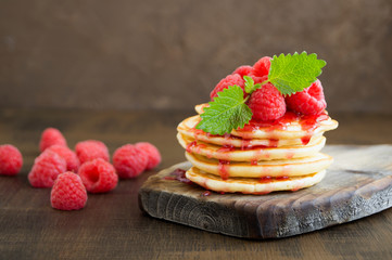  pancakes with raspberry on a dark background.
