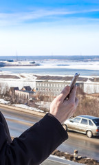 male hand with a smartphone on the background of nature.the concept of this video conversation or photograph