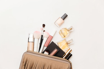 Makeup bag with cosmetic beauty products.  Beauty and Fashion concept. Cosmetic products flowing from Makeup bag on white background. Flat lay, top view. 