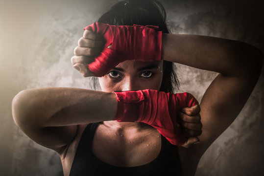 The female boxer looking aggressive with her gloves - Image