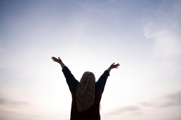 Unidentified silhouette happiness and joyful woman girl rise hand up during oceanview on blue sky background - Image