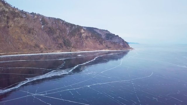 Mountains from aerial view.. Cracks in ice from aerial view. Winter in Siberia, Baikal Lake.