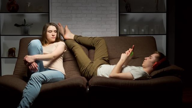 girl expresses dissatisfaction with her young man using smartphone for social media