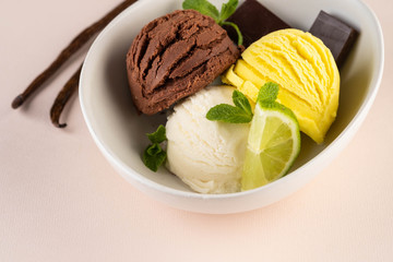 Trio of tasty chocolate vanilla and lime flavored frozen dessert in a white bowl.