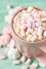 hot chocolate with marshmallows on turquoise surface