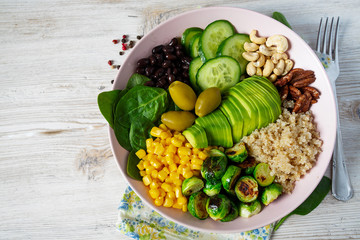 budha bowl with brussel cabbage, corn, quinoa, cucumbers,nuts, avocado and spinach
