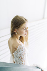  Wedding in the style of fine art. Beautiful bride in white interior Studio with stairs.
