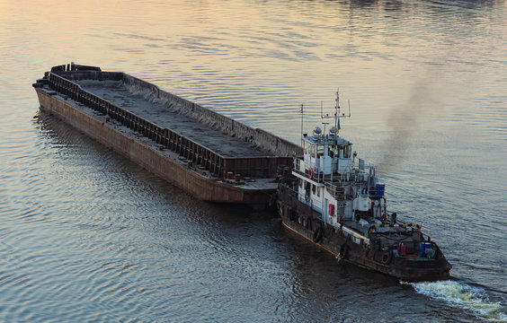 The Tug Boat Towing An Empty Barge. Evening View. Kyiv, Ukraine