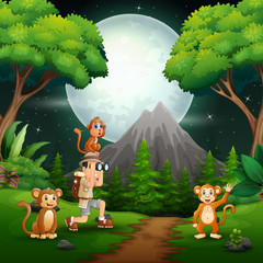 Obraz na płótnie Canvas Boy using binoculars with a monkeys in a forest