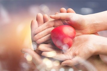 Man and woman holding red heart