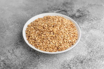 Casual porridge in a white saucer on a gray concrete background