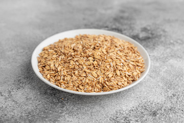 Casual porridge in a white saucer on a gray concrete background