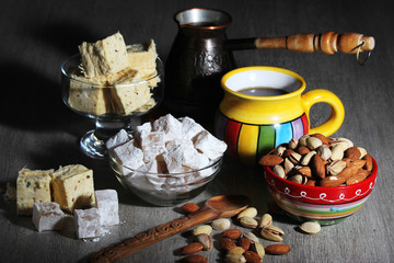Fototapeta na wymiar A mug of coffee and different oriental sweets: turkish delight, halva, almond and pistachio