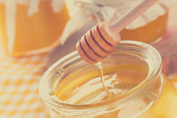 Honey background. Sweet honey in glass jar on wooden background.