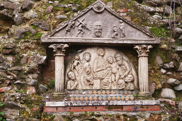 Ancient bas-relief in the public gardens of Scarperia, Tuscany, Italy