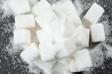 White sugar cubes over black background close up