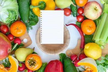 vegetables on a white background in the middle of a wooden plate and a piece of paper