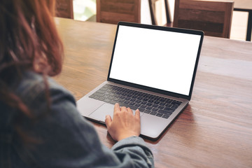 Mockup image of a woman using and touching on laptop touchpad with blank white desktop screen on...