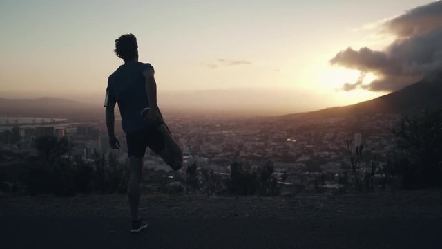 Full body length shot of a young white male stretching his body before doing exercise outdoors
