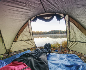 Man body in tent at lake in beautiful morning.