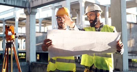 Portrait of construction engineers working on building site - obrazy, fototapety, plakaty