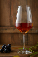 Pink wine in glass on rustic background