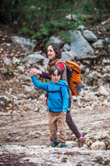 Naklejka premium A woman walks with her son through the forest.