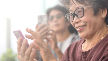 Happy elderly senior people society lifestyle concept. Ageing Asia women using smartphone share...