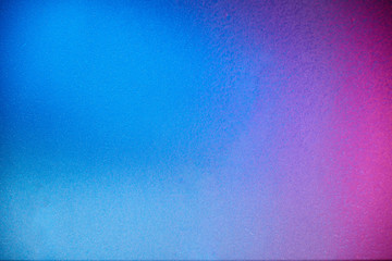 Full blur of a blue background and a small spot of pink
