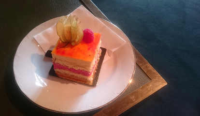 Cake decorated with groundcherry and raspberry on vintage style background