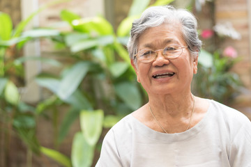 Happy senior society concept. Portrait of Asian female older ageing woman smiling with happiness in garden at home, nursing home, or wellbeing county
