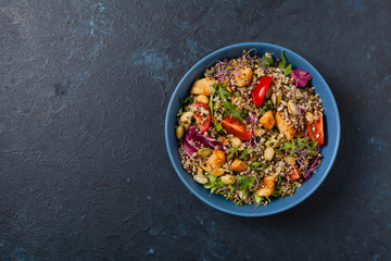 Salad with quinoa, avocado and chicken. Top view. Served in a blue bowl.