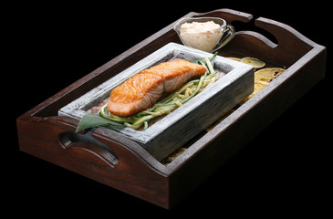 Salmon sous vide on a block of himalayan salt. On dark background