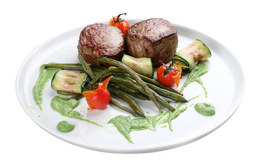 Veal medallions with green beans and Raclette cheese on white background