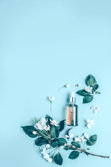 Natural organic cosmetics on blue background in a frame of flowers, blossoming apple tree.