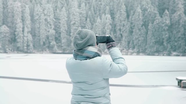 Woman taking video of winter landscape on her phone /  smartphone, Winter Landscape
