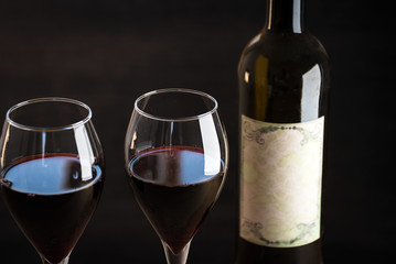 Pouring red wine into the glass against wooden background