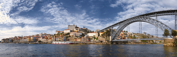 Fototapeta na wymiar Cityscape Panorama of the historic city of Porto, the Don Luis Bridge and the Douro River in Portugal in the day in spring
