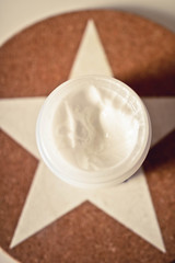 Open plastic jar with body cream close up view. Texture of the body cream.