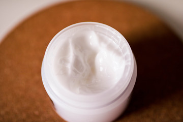 Fototapeta na wymiar Open jar with body cream close up view. Textured body cream.