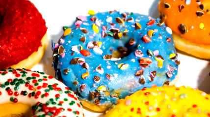 Sweet tasty donuts with colorful sprinkles isolated on white background
