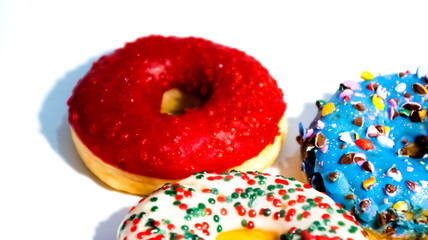 Sweet tasty donuts with colorful sprinkles isolated on white background