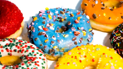 Sweet tasty donuts with colorful sprinkles isolated on white background