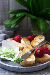 Butter with wild garlic, slices of bread and radish, ingredients for making a sandwich.