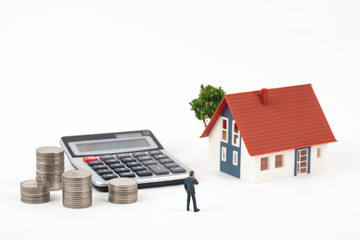 miniature businessman and coins with model house