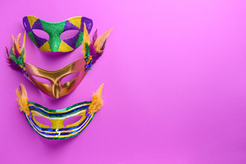 Festive masks on color background