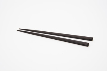 Black wooden chopsticks isolated on white background