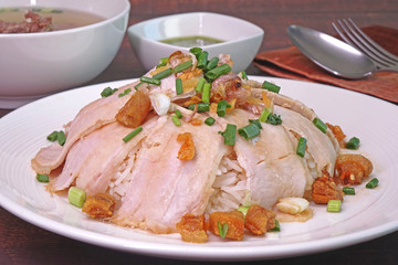 Slice grilled pork with rice, topping with fried pork rinds, pickled garlic and spring onions served with pork spare ribs soup and spicy green chili sauce. Famous Chinese / Cantonese cuisine.