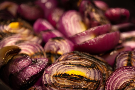 Closeup of red onion grilled lie on a black frying pan