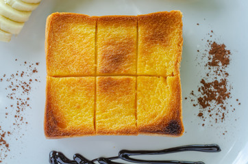 Slice of toasted bread on white dish, set of honey toasted.